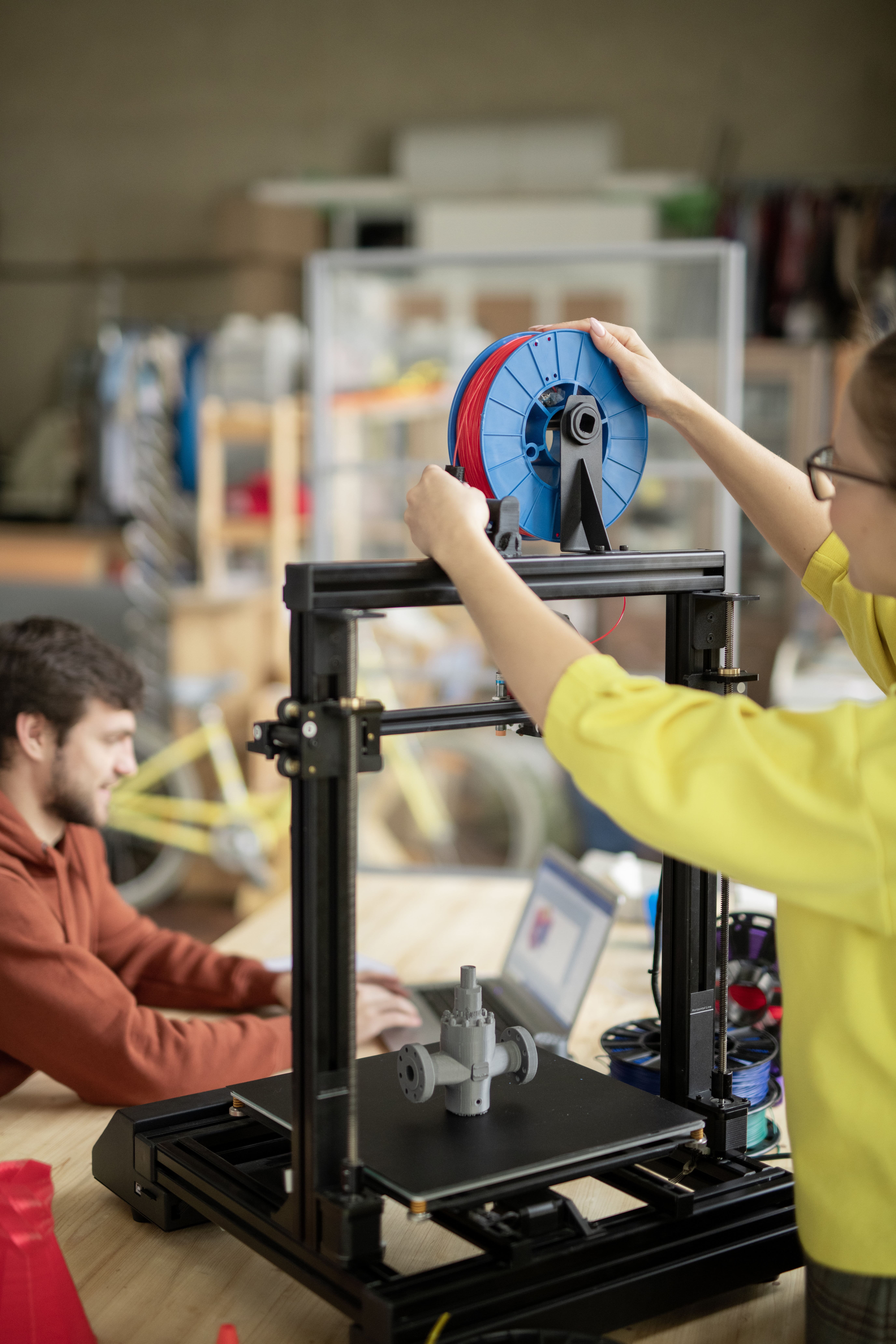 A woman putting on a SLS printing roller on a 3d printing